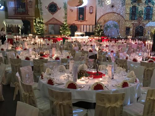 a large banquet hall with white tables and chairs at Burg Wegberg Hotel & Eventlocation in Wegberg