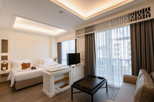 a hotel room with a bed and a large window at Siam Tharadol SHA Extra Plus in Bangkok