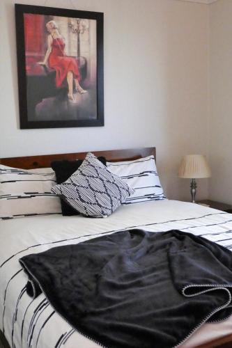 a bed with a black blanket on top of it at A Market Place Mudgee in Mudgee