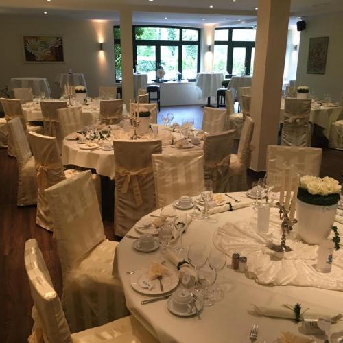 a dining room with white tables and white chairs at Burg Wegberg Hotel & Eventlocation in Wegberg