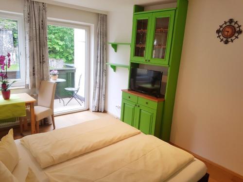 a bedroom with a green cabinet and a television at Apartment Gastein in Bad Gastein