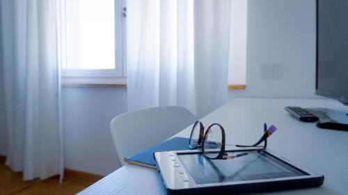 a laptop with a pair of glasses on a table at Hotel Mistral in Oristano
