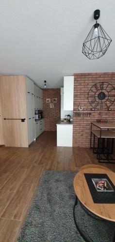 a living room with a table and a kitchen at Apartamenty Bartnicza A in Bielsko-Biała