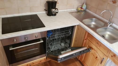 an empty dishwasher in a kitchen next to a sink at Casa Margherita Top in Sorico