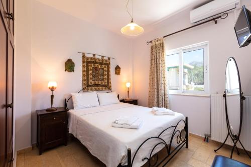 a bedroom with a bed and a window at Andi Vacation Home in Lefkogeia