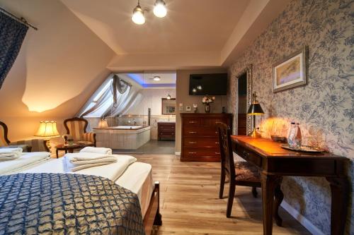 a bedroom with a bed and a desk and a bathroom at Takler Kúria in Szekszárd