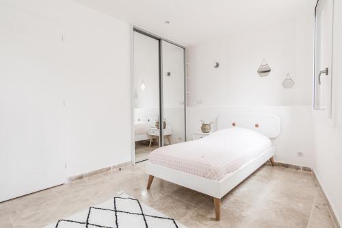 a white bedroom with a bed and a mirror at LOCAPPART CASSIS en Provence in Cassis