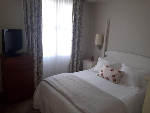 a bedroom with a white bed and a window at Habitación con baño individual in Bilbao