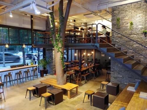 a restaurant with a staircase and tables and chairs at Wegoinn Hostel in Seoul
