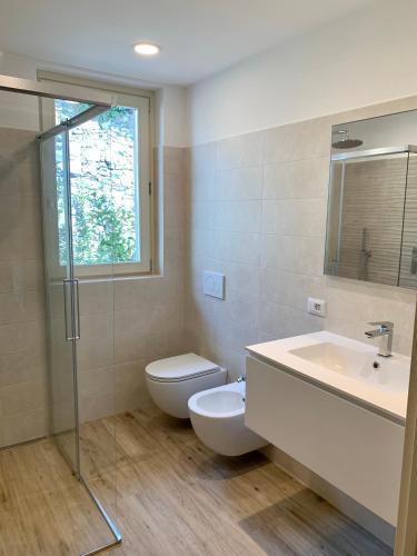 a bathroom with a toilet and a sink and a shower at House & Pool in Mergozzo