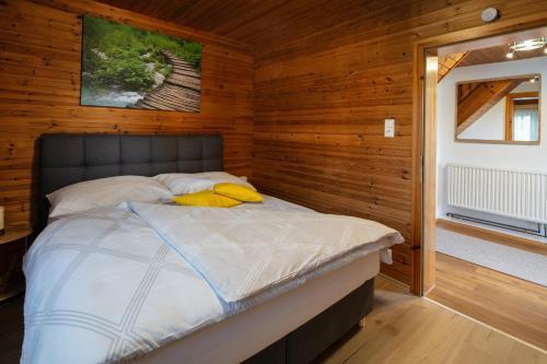 um quarto com uma cama num quarto com paredes de madeira em Ferienhaus Stoiser em Sankt Stefan ob Stainz