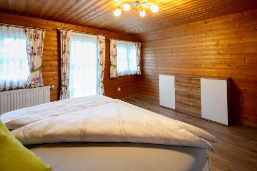 a bedroom with a bed in a wooden cabin at Ferienhaus Stoiser in Sankt Stefan ob Stainz