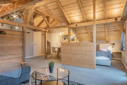 Cette chambre dispose de plafonds en bois, d'un lit et d'une table. dans l'établissement Buche, à Interlaken