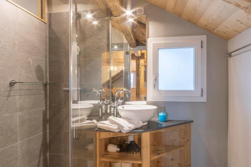 une salle de bain avec deux lavabos et une douche dans l'établissement Buche, à Interlaken