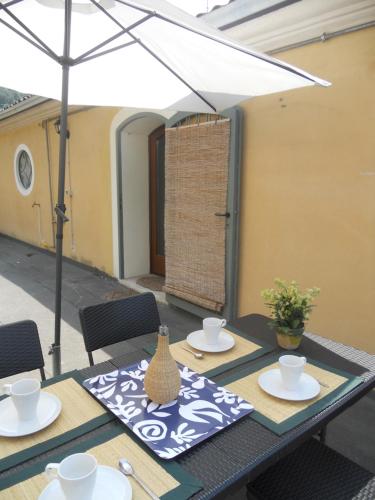 a table with chairs and an umbrella on a patio at Klimt's Mill overlooking Port in Malcesine