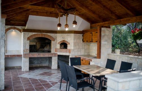 an outdoor kitchen with a table and a fireplace at Apartments Anica Kampor in Rab