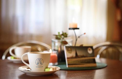 una taza de café en una mesa con un ordenador portátil en DOMUS MARIAE Gietrzwałd, en Gietrzwałd