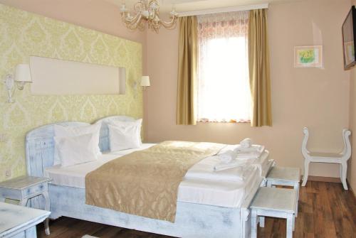 a bedroom with a large bed and a window at Takler Kúria in Szekszárd