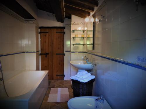 a bathroom with a tub and a sink and a toilet at Casale Grillo in Cortona