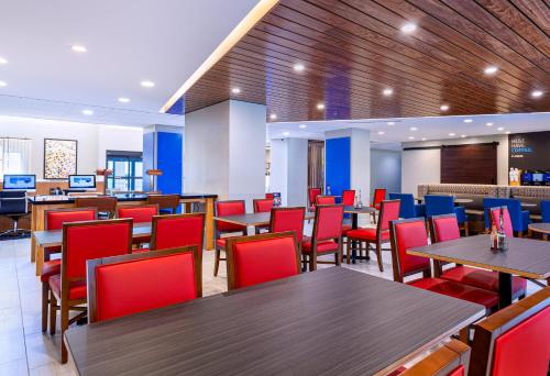 a dining room with tables and red chairs at Holiday Inn Express Tampa-Brandon by IHG in Brandon