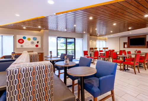 a restaurant with blue chairs and tables and red chairs at Holiday Inn Express Tampa-Brandon by IHG in Brandon