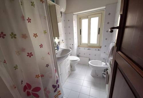 een badkamer met een wastafel, een toilet en een raam bij In Vacanza a Gaeta - Il Nido dell'Artista in Gaeta