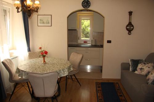 a living room with a table and chairs and a kitchen at Apartman Rino in Bašanija