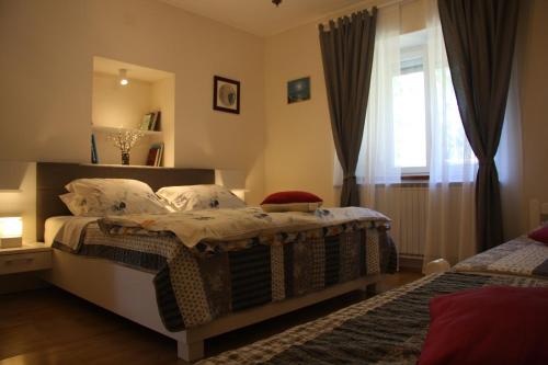 a bedroom with two beds and a window at Apartman Rino in Bašanija
