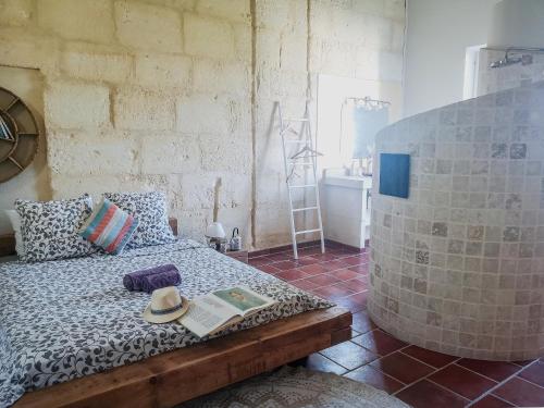 een slaapkamer met een bed met een boek erop bij Mas de l'Hermitage in Moulès