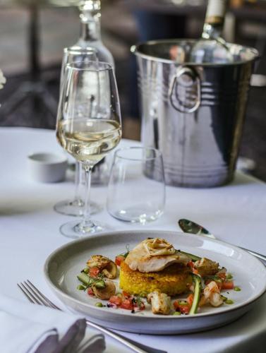 a plate of food on a table with a glass of wine at Queens Hotel & Spa Bournemouth in Bournemouth