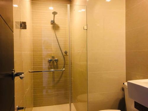 La salle de bains est pourvue d'une douche avec une porte en verre. dans l'établissement One Palm Tree Villas-Terminal 3 Pasay Manila, à Manille