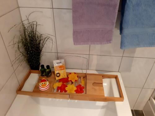a wooden tray with toys on top of a bathroom sink at Ferienwohnung Haus Gintz in Blieskastel