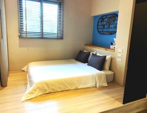 a bedroom with a white bed and a window at Enjoy Homestay in Tainan