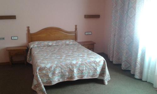 a bedroom with a bed and two tables and a window at San Glorio in Llánaves de la Reina