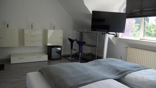 a bedroom with a bed and a flat screen tv at Hotel Specht by Trotmannia in Dortmund