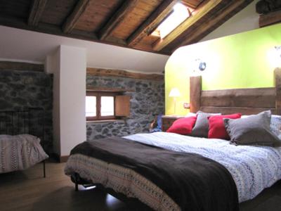 1 dormitorio con 1 cama grande con almohadas rojas en Apartamento rural Casa Arritxenea, en Leitza