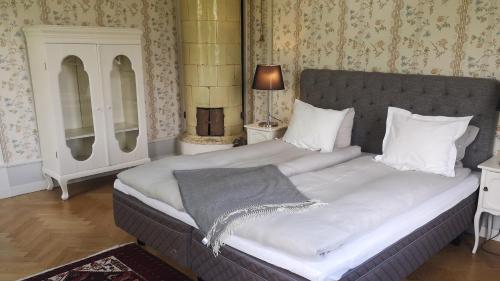 a bedroom with a large bed with white pillows at Hoby Gård B&B in Bräkne-Hoby