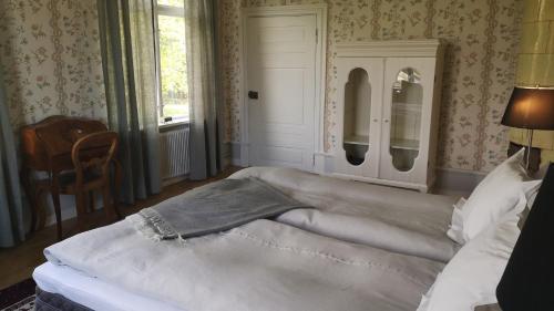 a large bed in a bedroom with a window at Hoby Gård B&B in Bräkne-Hoby