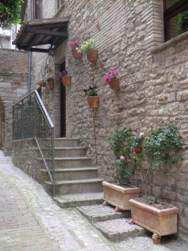 a stone building with stairs and potted plants on it at la corta di spello camere in Spello