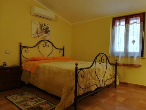 ein Schlafzimmer mit einem Bett mit orangefarbenen Kissen und einem Fenster in der Unterkunft la corta di spello camere in Spello