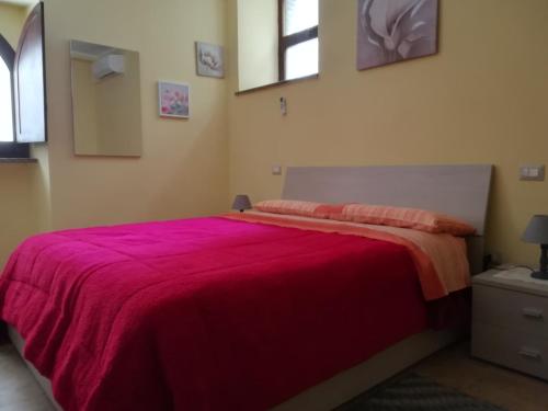 a bedroom with a bed with a red blanket at la corta di spello camere in Spello