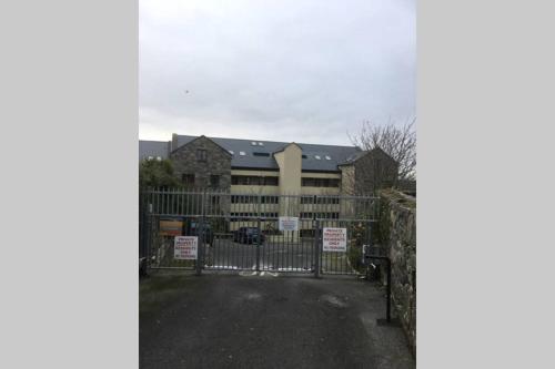 a gate in front of a building with signs on it at Waterfront apartment completely refurbished in Westport