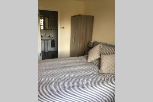 a bedroom with a bed with a striped comforter at Waterfront apartment completely refurbished in Westport