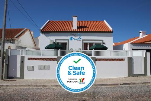 a house with a clean and safe sign in front of it at Casa do Bairro by CosyCasa Praia Peniche in Peniche