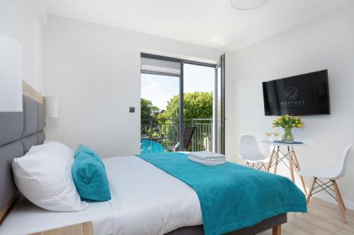 a bedroom with a bed and a balcony at Morska 5 in Niechorze