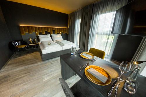 a hotel room with a bed and a dining table at MY HOME MY HOTEL Rosenheim in Rosenheim