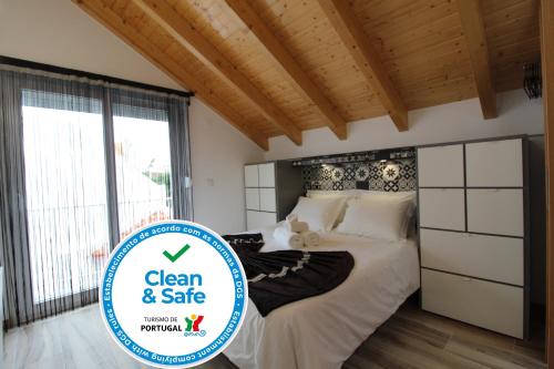 a bedroom with a bed with a sign that says clean and safe at Casa das Rendas by CosyCasa Praia Peniche in Peniche