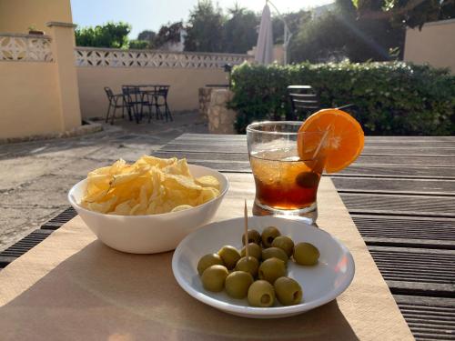 un tavolo con una ciotola di patatine e un drink di Hostal El Callejón a Tarragona