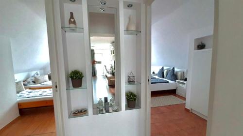 a room with a mirror and a bedroom with a bed at Munkácsy Apartmanok in Balatonfenyves