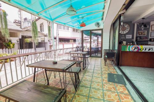 a restaurant with tables and chairs on a balcony at Born Guest House in Chiang Mai